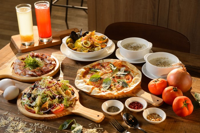 Table full of food with pizza, salad, and drinks