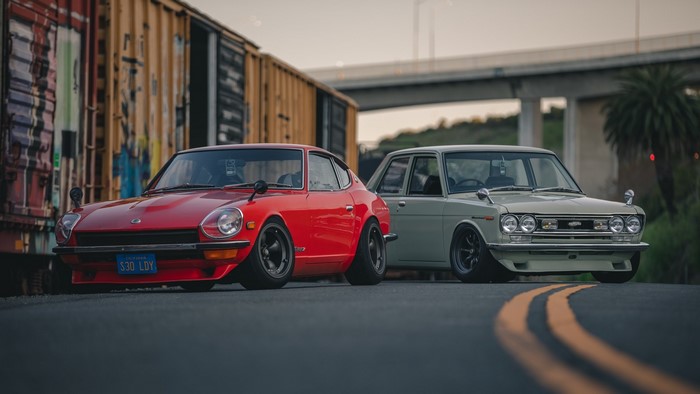 Red Nissan S30 and Grey Datsun Bluebird parked