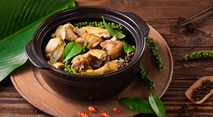 Chicken stew with peppercorns and leaves in a pot