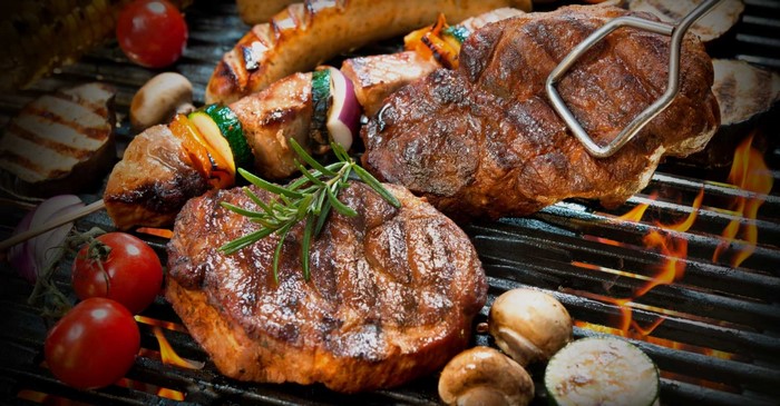 Steak and vegetables grilling on a barbecue