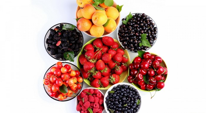 Bowls of assorted berries and apricots