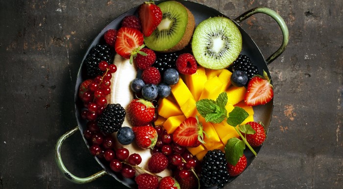 Colorful fruit platter with mango, berries, kiwi, and strawberries