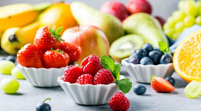 Assortment of fresh fruits including berries, bananas, and oranges