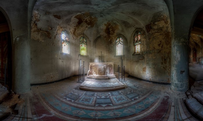 Abandoned crypt interior with altar and stained glass windows