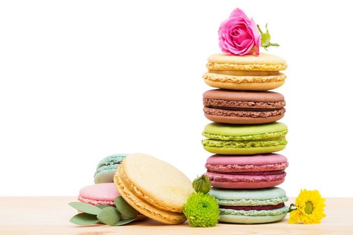 Colorful macarons with flowers and eucalyptus