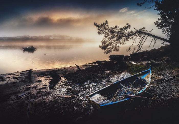 Old boat on a foggy shore