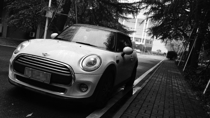 White Mini Cooper parked on a wet street in Wuhan, China