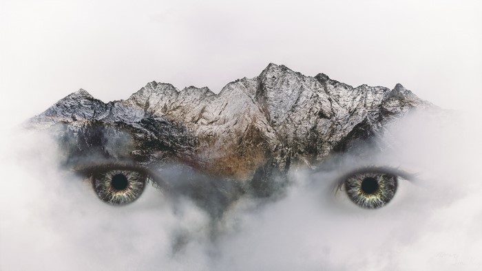 Double exposure of eyes and snowy mountains
