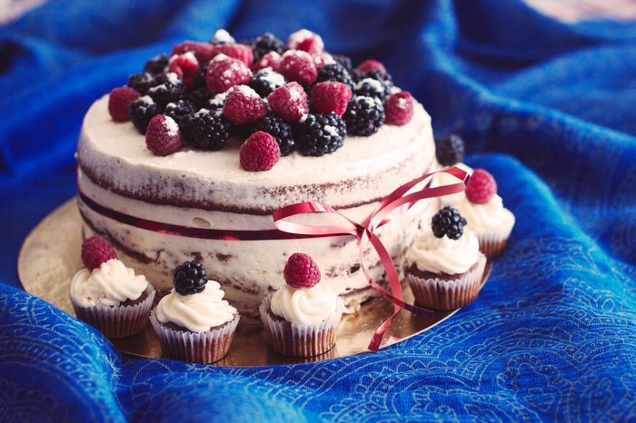 Naked cake with berries and cupcakes