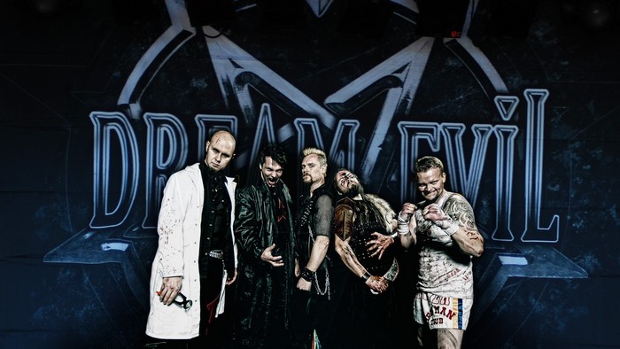 Dream Evil band members posing in front of logo