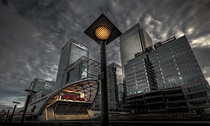 Canary Wharf buildings and station in London under cloudy sky