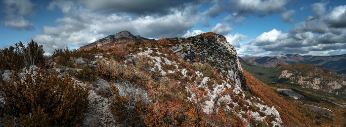 Rocky mountain landscape with autumn foliage and clouds
