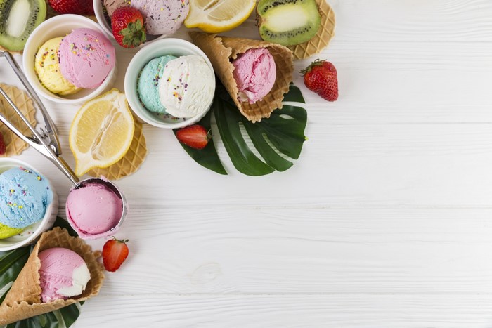 Assortment of ice cream scoops, fruits, and cones