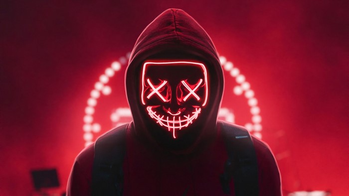 Person in a red hoodie wearing a neon purge mask