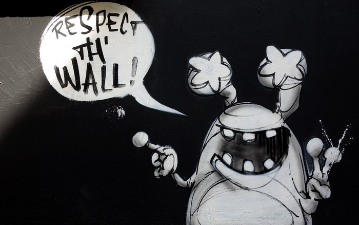 Graffiti monster with speech bubble saying Respect Th' Wall