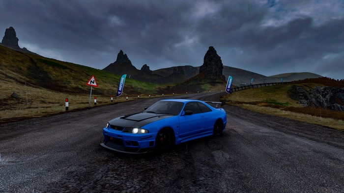 Nissan GT-R R33 on a road with mountains