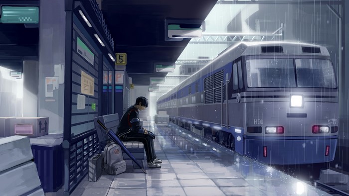 Man waiting for train at station in the rain