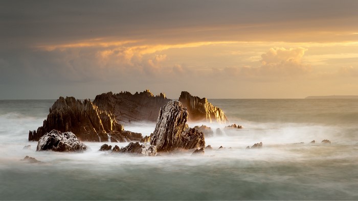 Jagged rocks in the sea at sunset