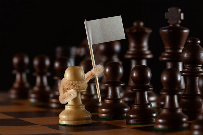 White pawn holding a flag on a chessboard