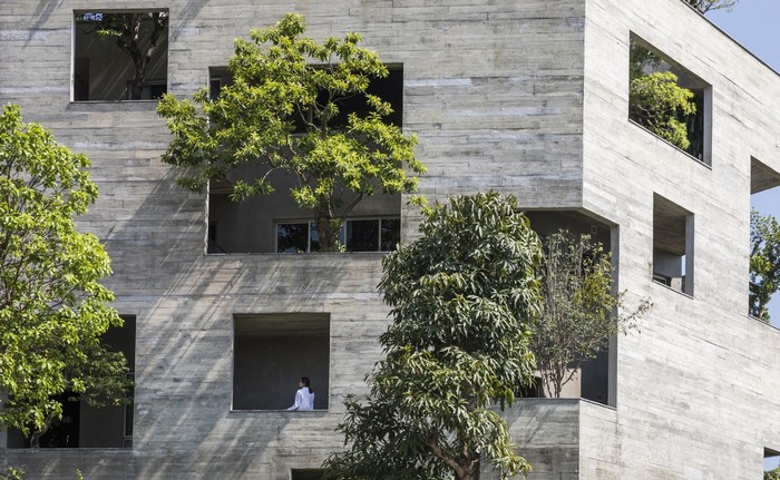Modern concrete architecture with trees and a person