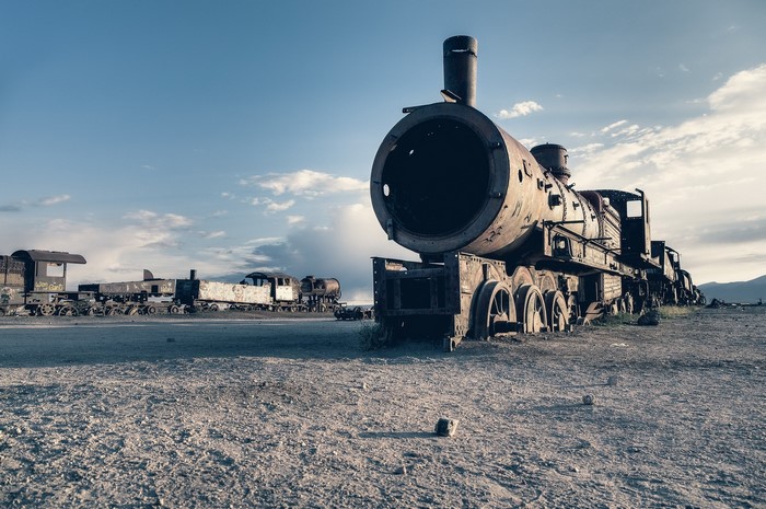 Abandoned train graveyard under a cloudy sky