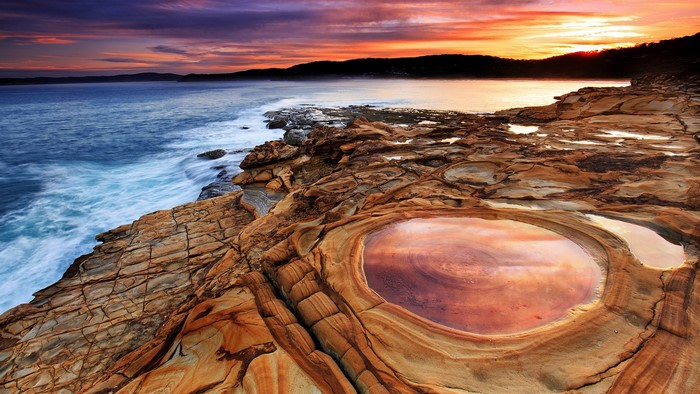 Sunset over the rocky coast of Australia with the Pacific Ocean