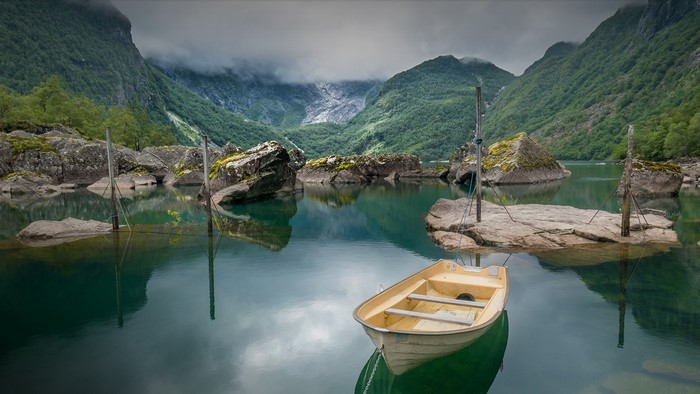 Boat on a lake in a Norwegian fjord with mountains