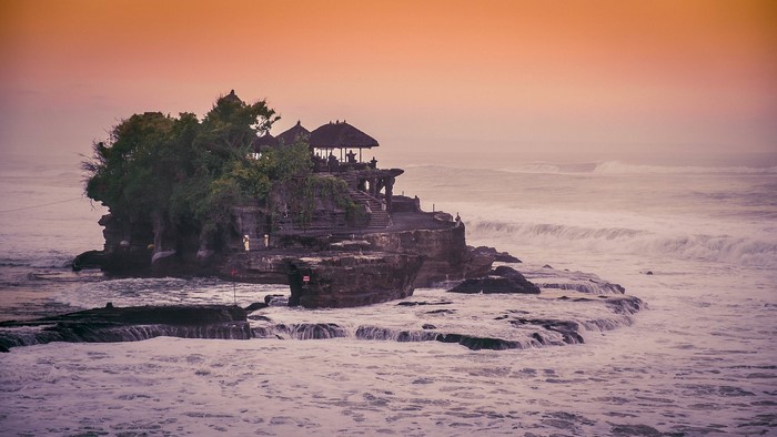 Tanah Lot Temple on a rocky island in Bali at sunset