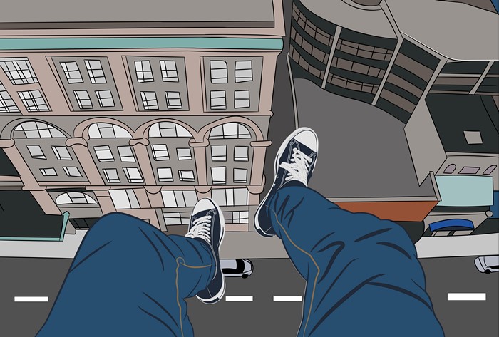 Legs and shoes overlooking city buildings