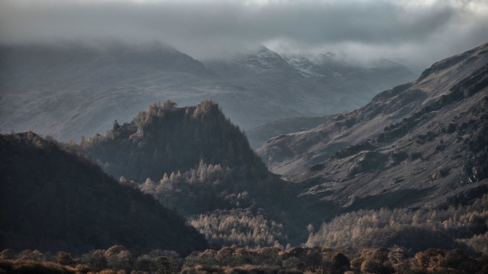 Misty mountains and forested valley in the Lake District