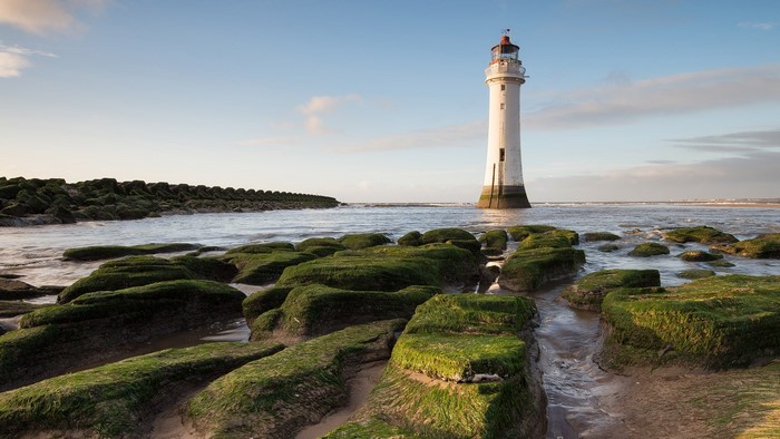 Perch Rock Lighthouse on a rocky shore with moss