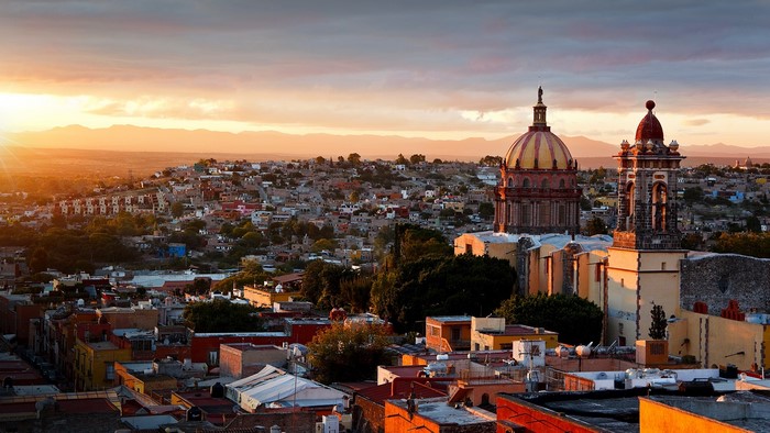 Sunset over a Mexican city with church domes