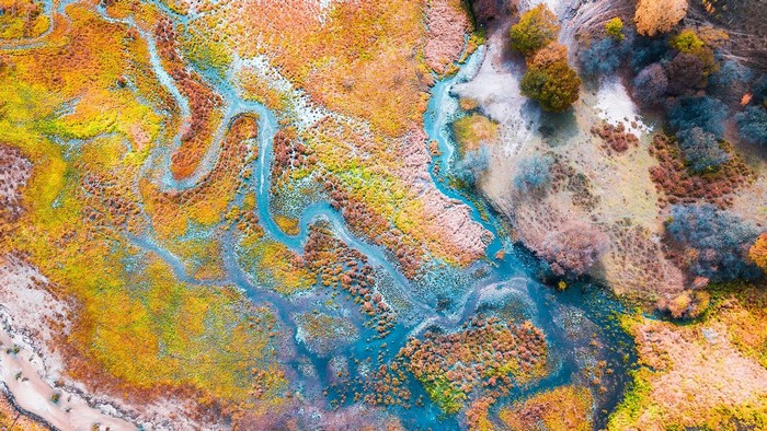 Aerial view of a winding river through colorful autumn landscape in China
