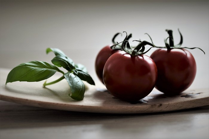Tomatoes and basil on a wooden board