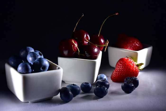 Cherries, strawberries, and blueberries in bowls