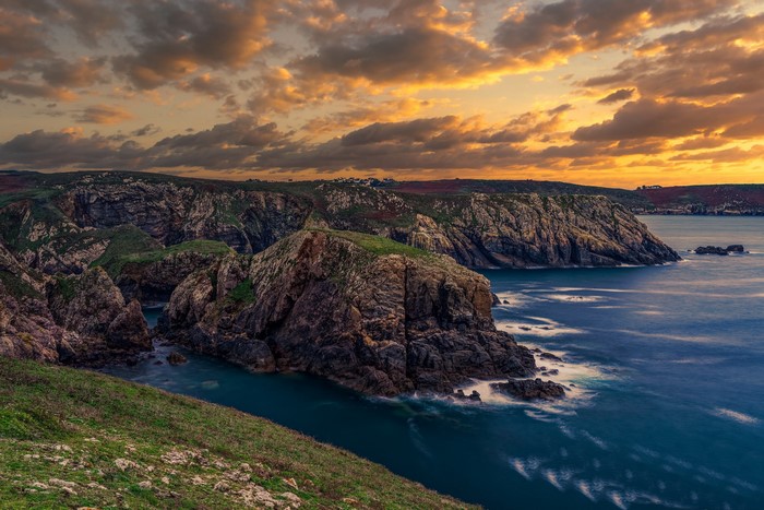 Rocky coast of France at sunset with dramatic clouds