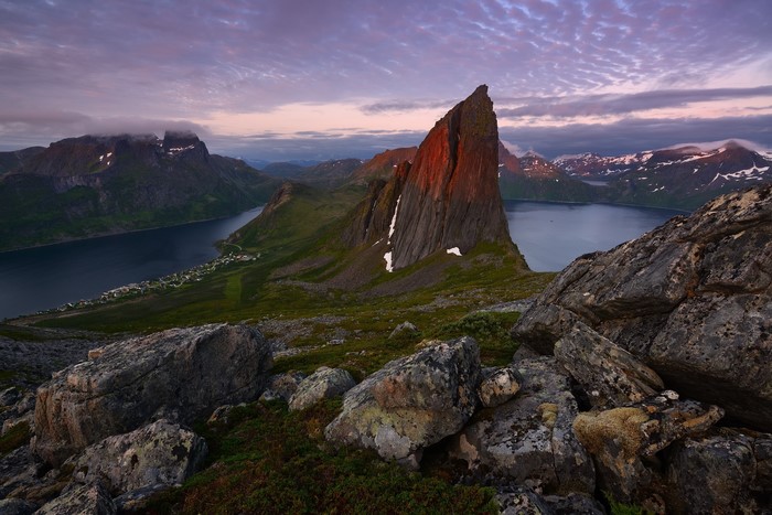 Sharp mountain peak illuminated by sunset over a Norwegian fjord