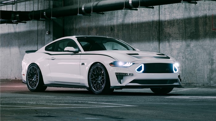 White Ford Mustang parked in a concrete parking garage