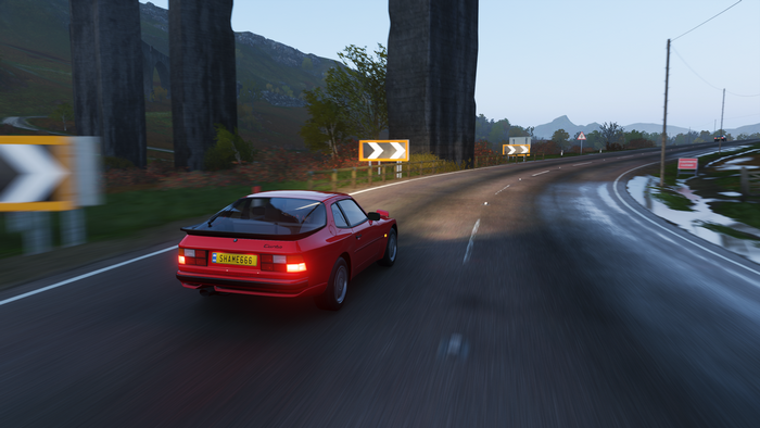Red Porsche 944 Turbo driving on a wet road in Forza Horizon 4