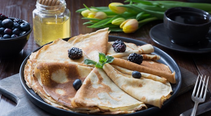 Pancakes with berries, honey, and coffee