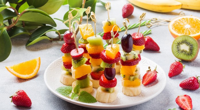 Colorful fruit skewers with strawberries, kiwi, oranges, and grapes