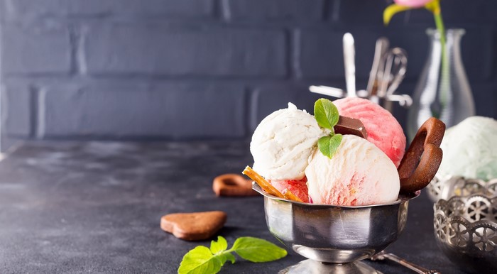 Assorted ice cream scoops in a silver bowl with cookies