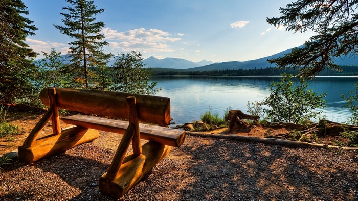 Wooden bench overlooking a lake in Jasper National Park, Canada