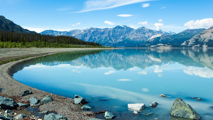 Lake reflection of mountains and forest in Yukon, Canada