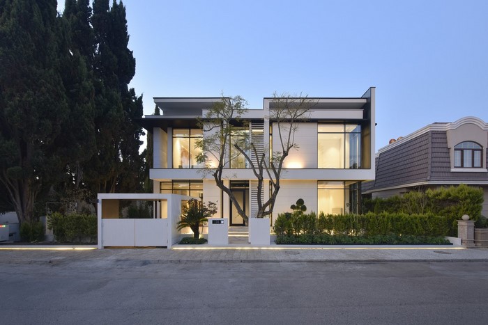 Modern white house with large windows and trees