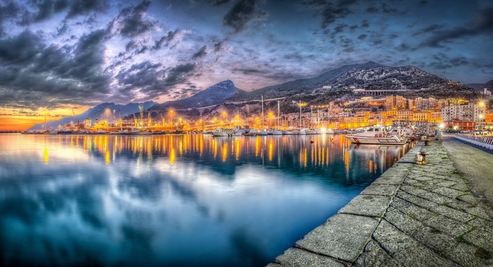 Salerno cityscape with boats and mountains at dusk