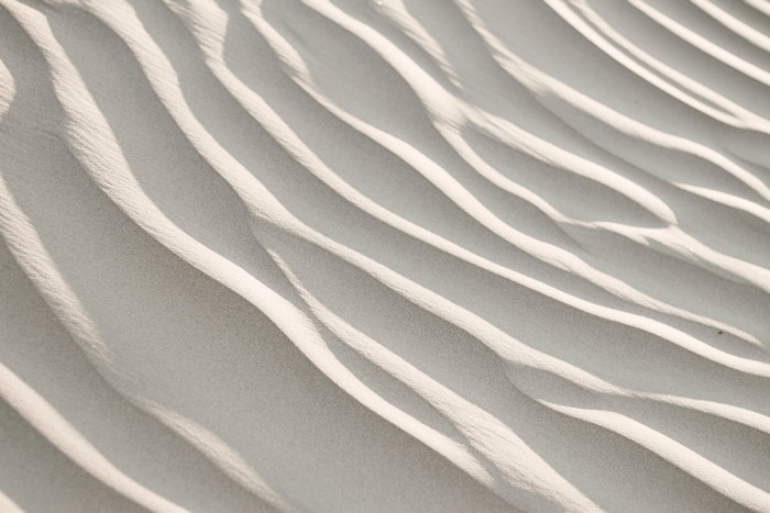 Sand dunes with rippling patterns and shadows