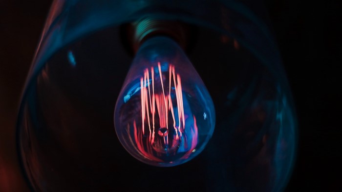Close-up of a glowing Edison lightbulb with blue and red light