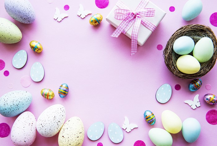 Easter eggs and gift box on pink background