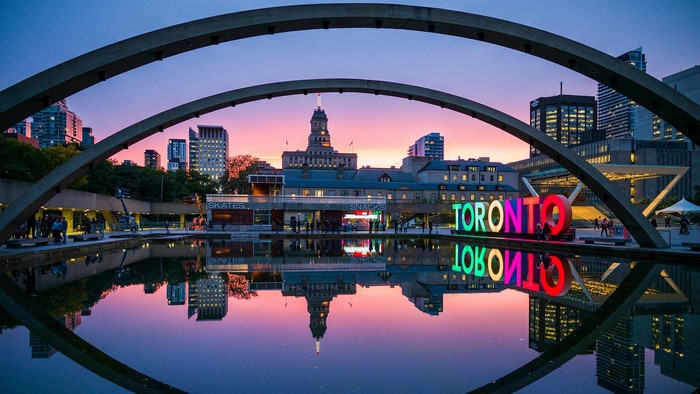 Toronto sign reflected in water at dusk